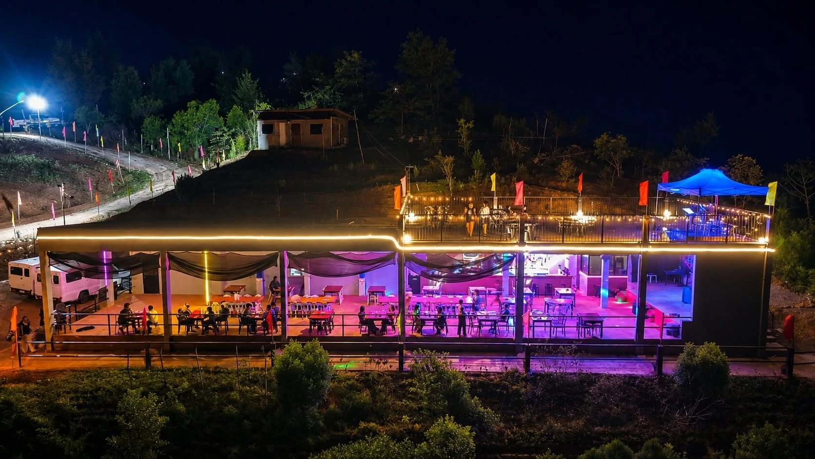 Aerial night view of Laaganan Skybar & Restaurant in Basilisa, Dinagat Islands, with the Main Dining Area lit in colourful lights and the Rooftop Skydeck above.